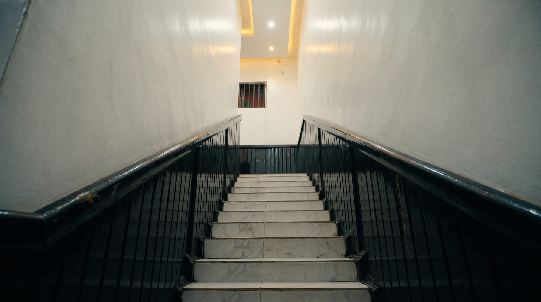The marble staircase with black handrails inside the property